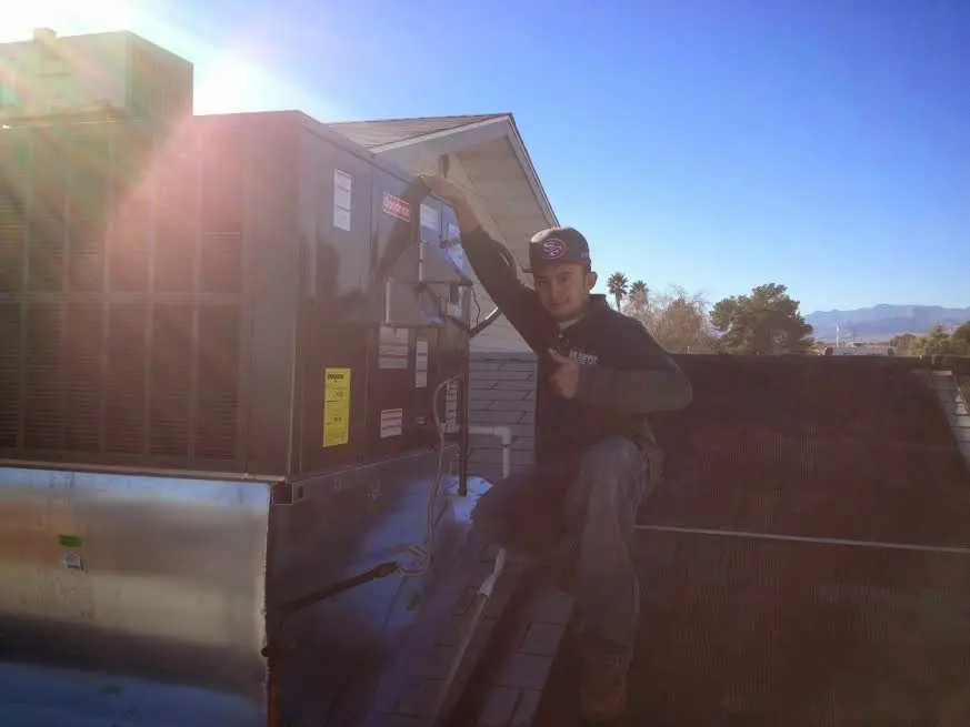 HVAC technician performing AC Tune-Up on a rooftop unit in Palestine